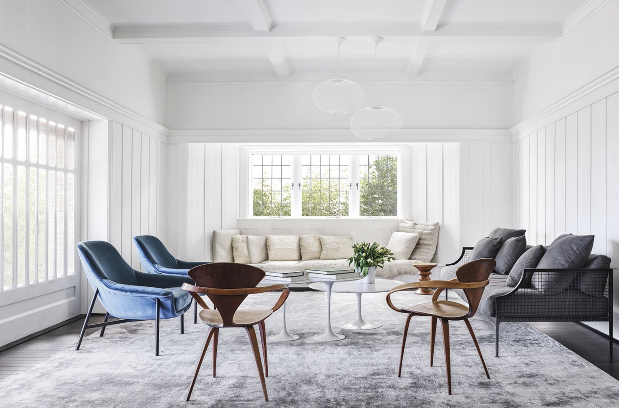 Salón blanco con sofá gris y butacas en azul.
