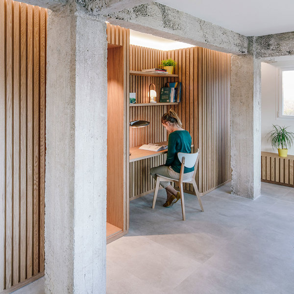 Revestimiento alistonado de madera, con columna y vigas de hormigón a la vista y zona de trabajo