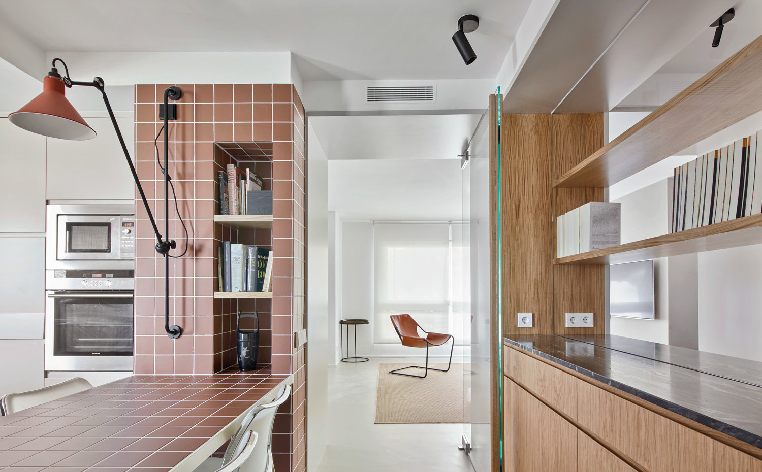 Cocina con mesa de office, estanteri´a a modo de hornacina y gran aplique extensible en pared 