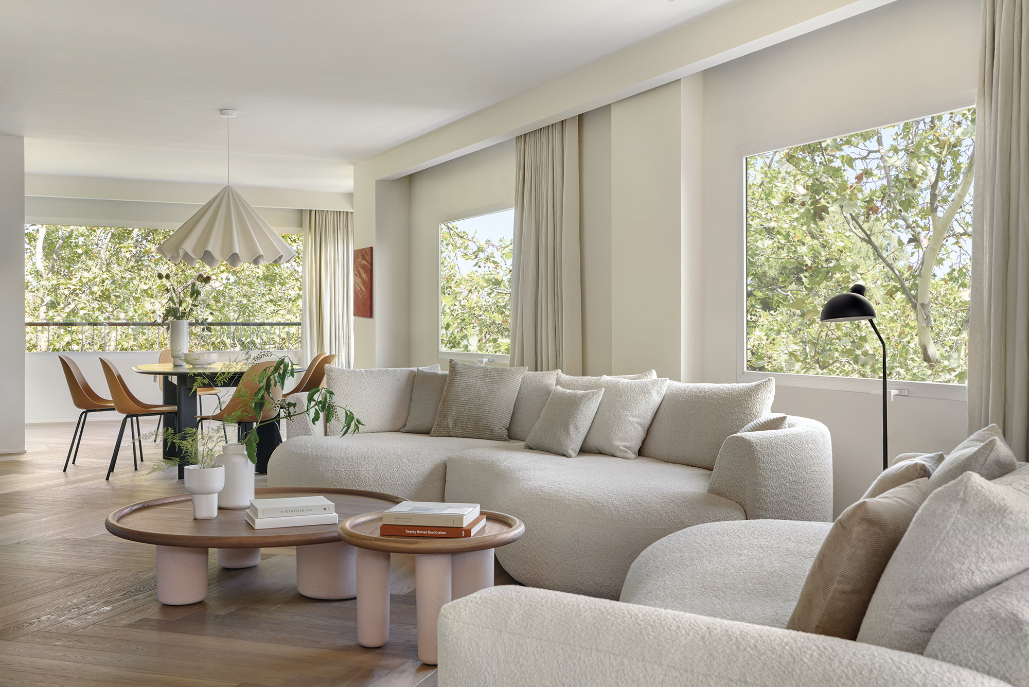 Salón con sofás curvos y mesas de hormigón.
