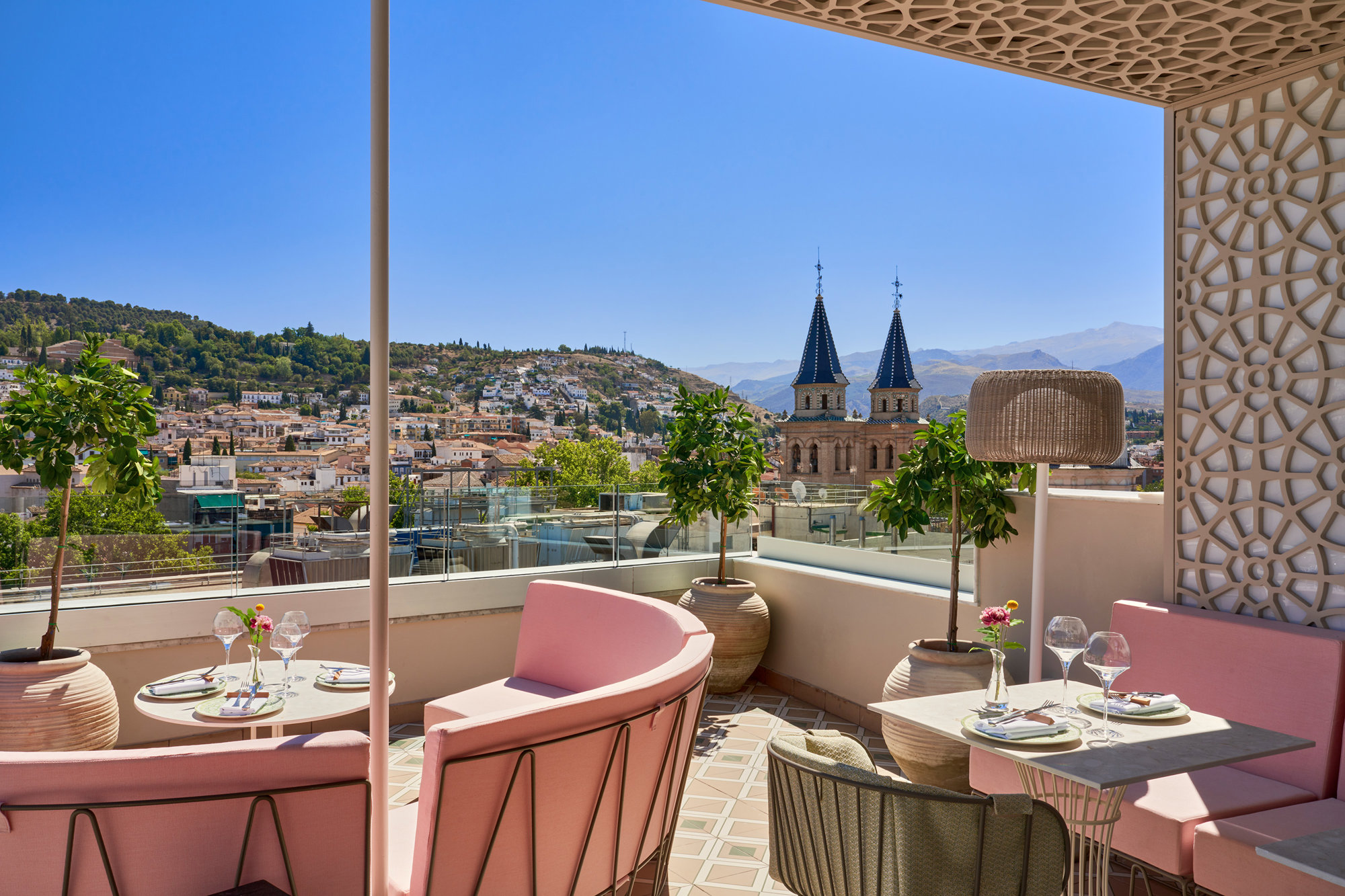Terraza con sofás rosas con vistas a Granada. 