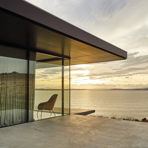 Un oasis playero que flota sobre la arena y las rocas: así es esta increíble casa moderna de madera, hormigón y piedra