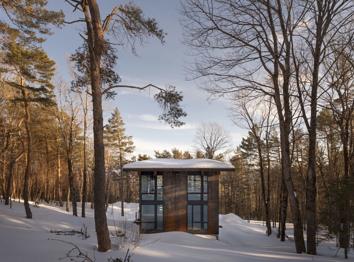 Cabaña en el bosque rodeada de nieve.