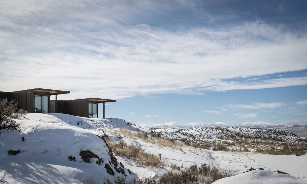 Cabaña de madera rodeada en la nieve.