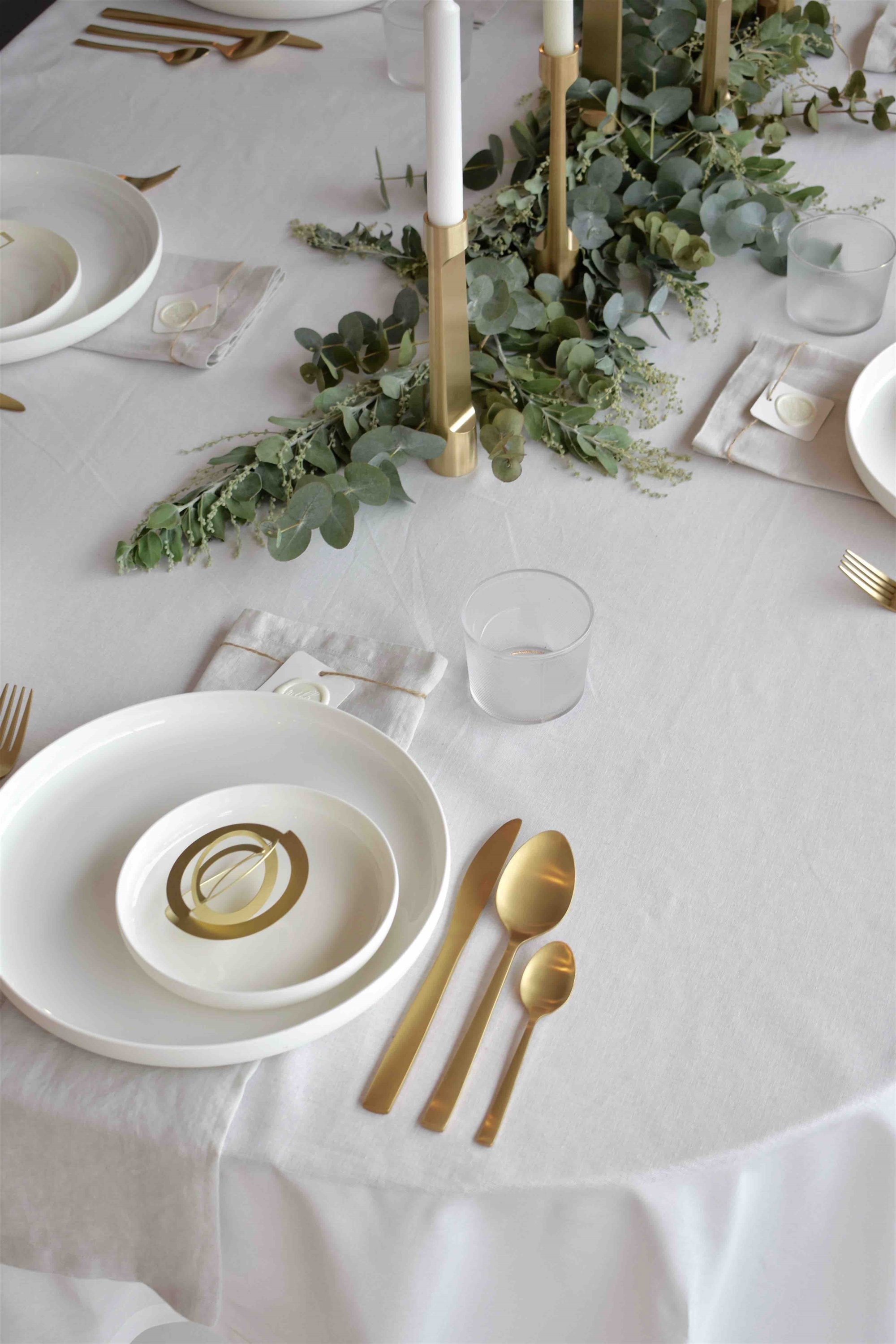 Mesa de navidad con decoracio´n en color dorado y mantel blanco