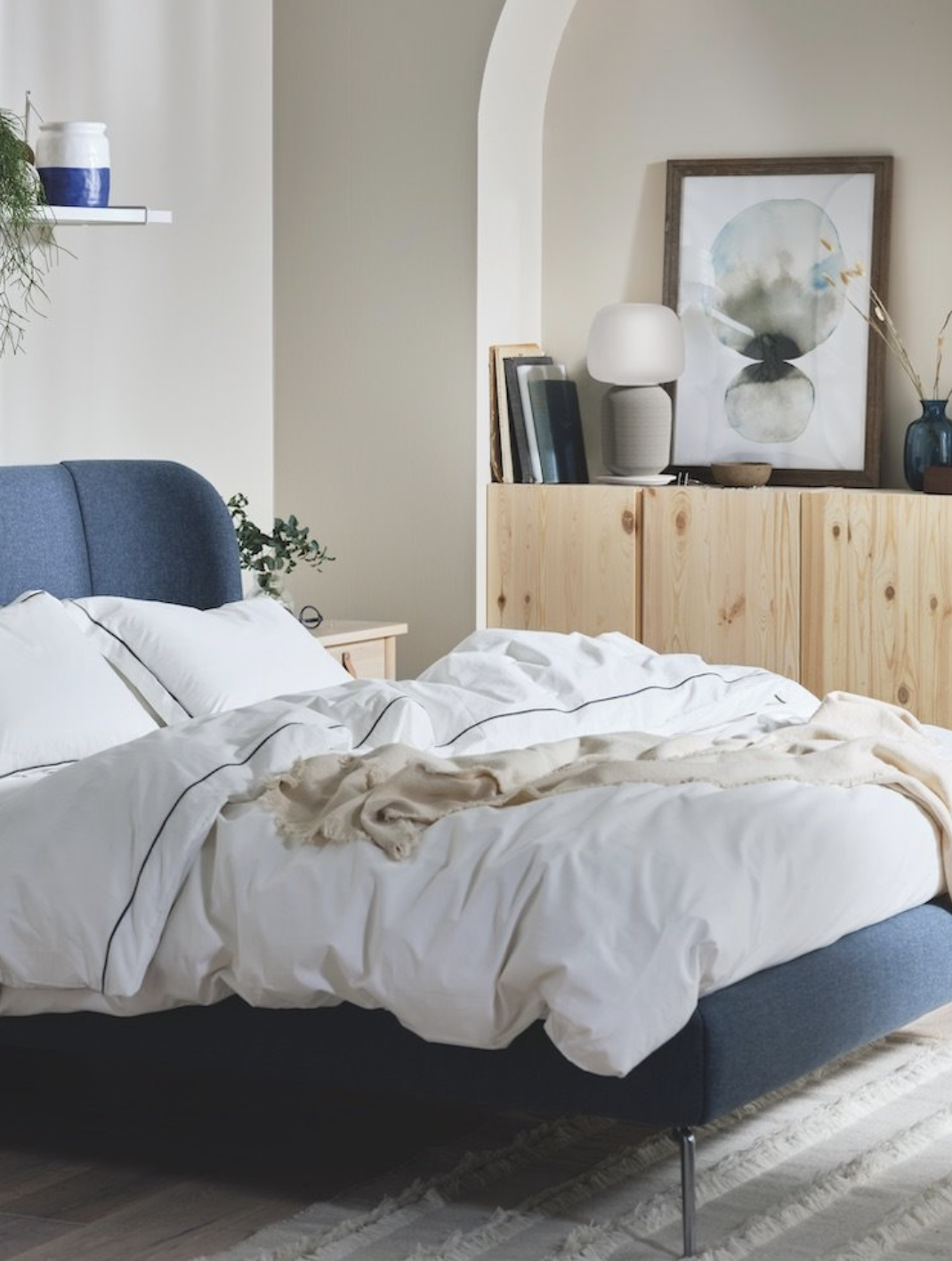 Dormitorio de invierno con cama tapizada y ropa de cama blanca.