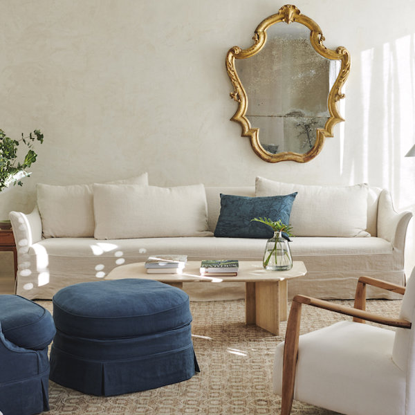 Sofa con tapiceria blanca y espejo con marco dorado