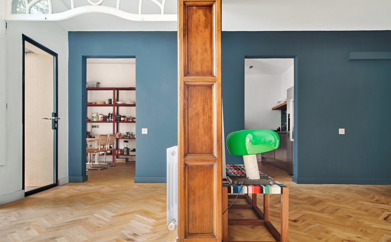 Salón con pared de color gris y suelos de madera.