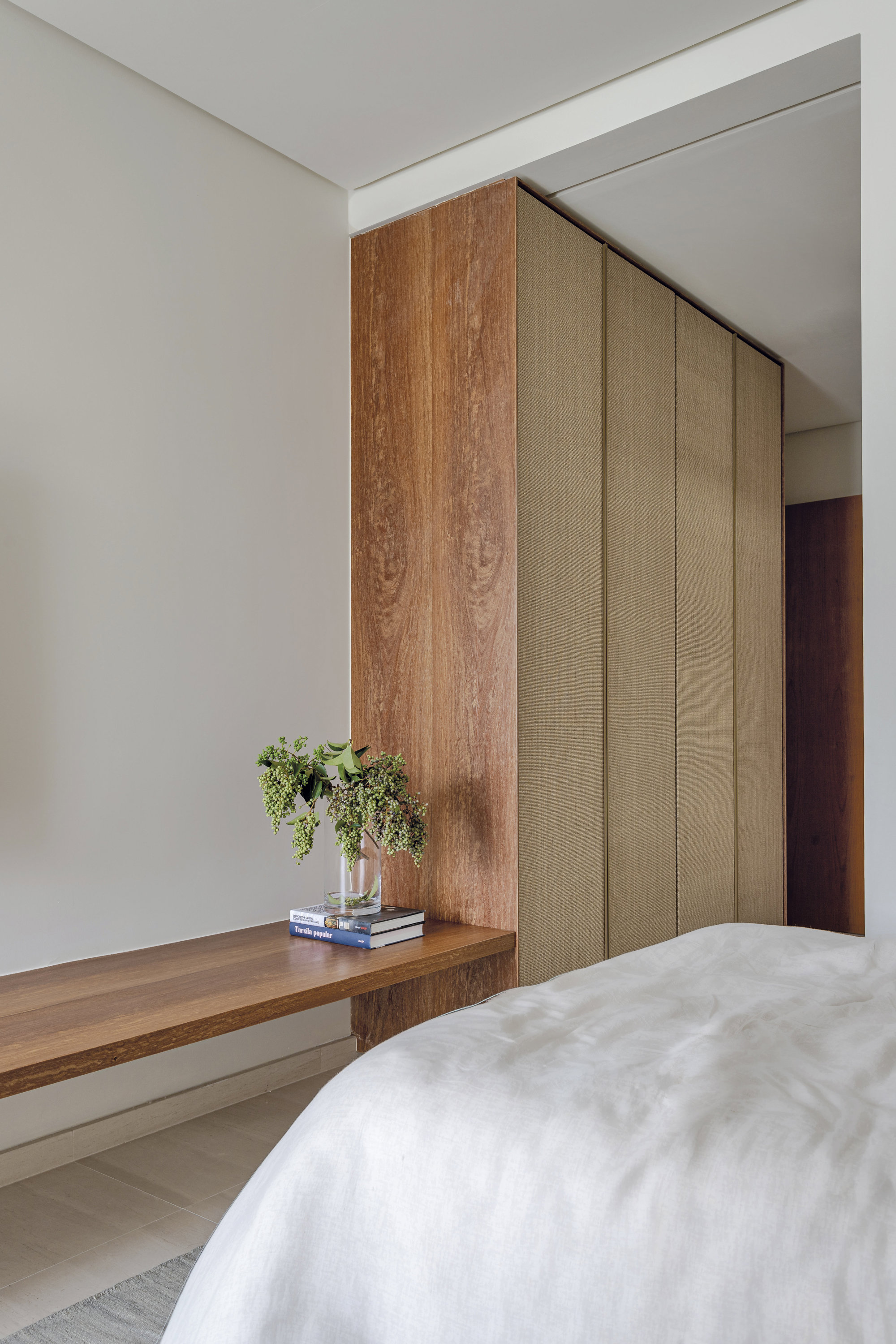 banco de madera junto a la cama y al armario