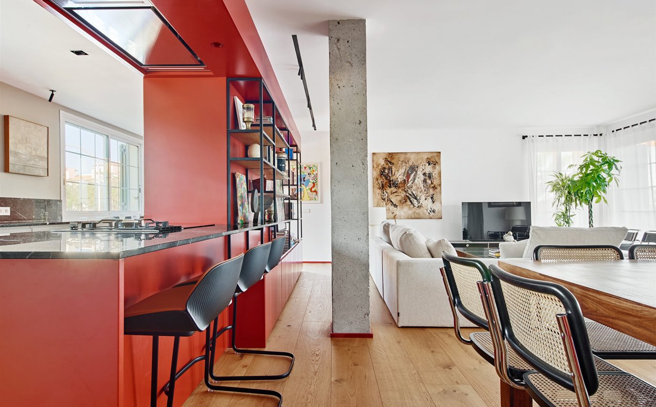 Cocina con barra y taburetes altos de color negro muebles de color rojo