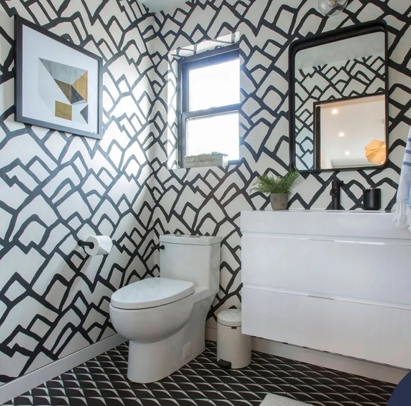baño con paredes con ptarones en blanco y negro