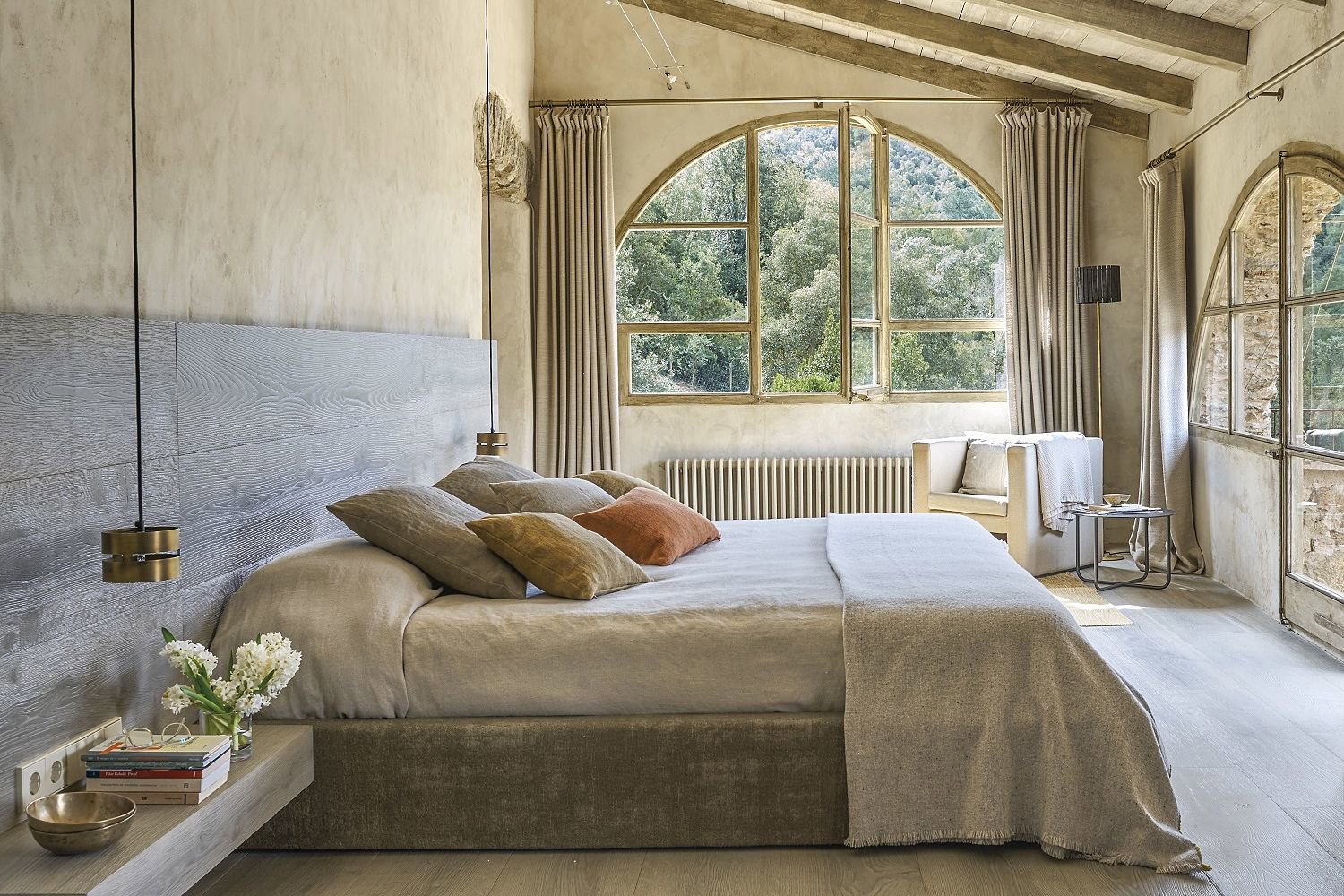 Dormitorio con cabecero de madera y cortinas.