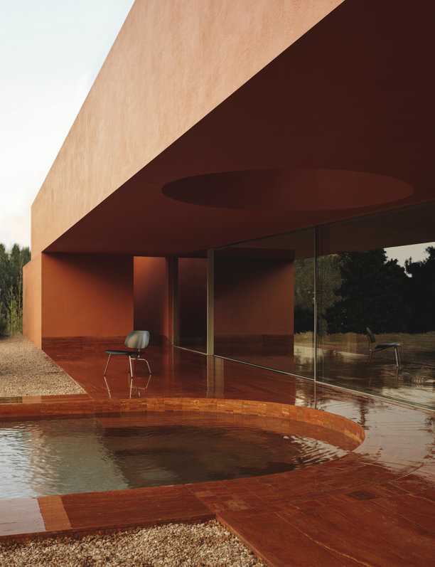 Los olivos centenarios y el travertino iraní, protagonistas de esta casa en Valencia que se camufla con el atardecer