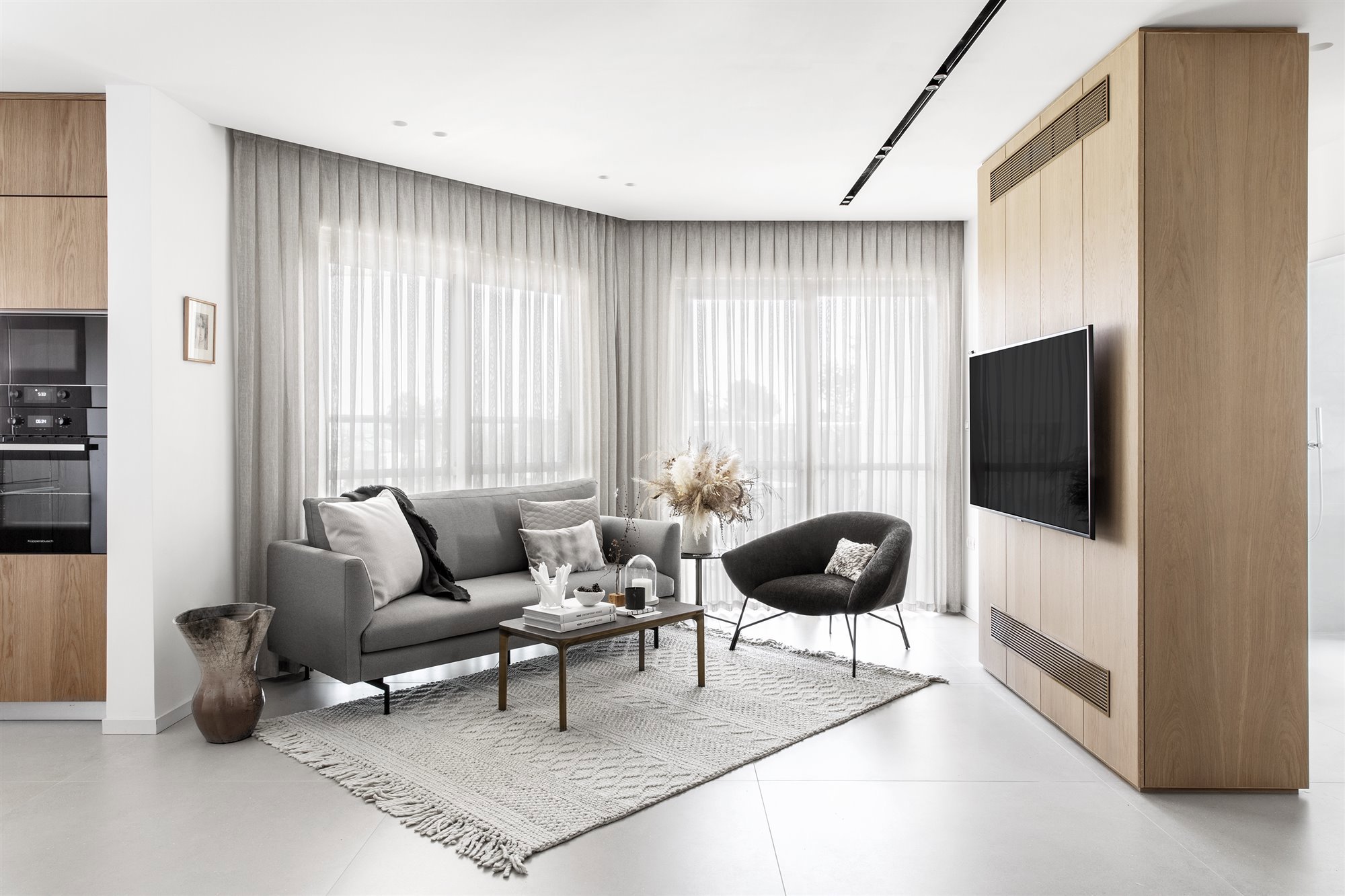 salon con sofa de color gris y mueble para Tv de madera