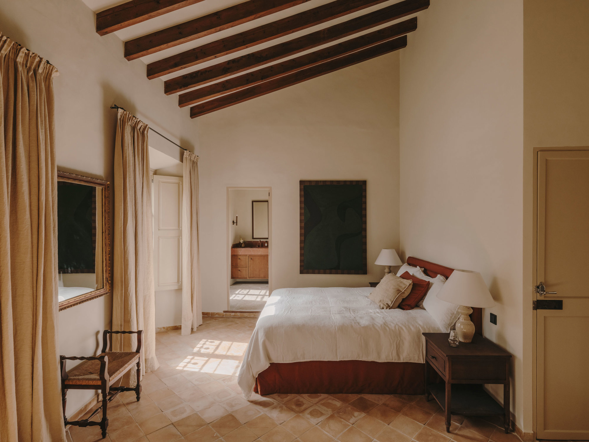 Dormitorio con vigas de madera y suelo de barro estilo rústico