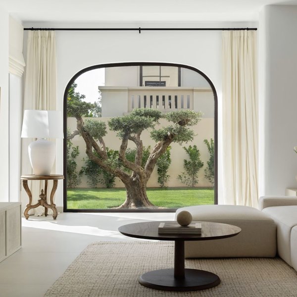 El oasis minimalista, elegante y cálido de esta casa en Dubái que tiene como protagonista un olivo de más de 70 años en el centro de un gran ventanal